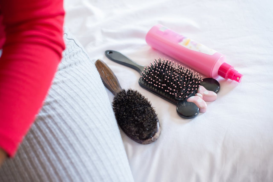 Plusieurs brosses à cheveux sur un lit gris