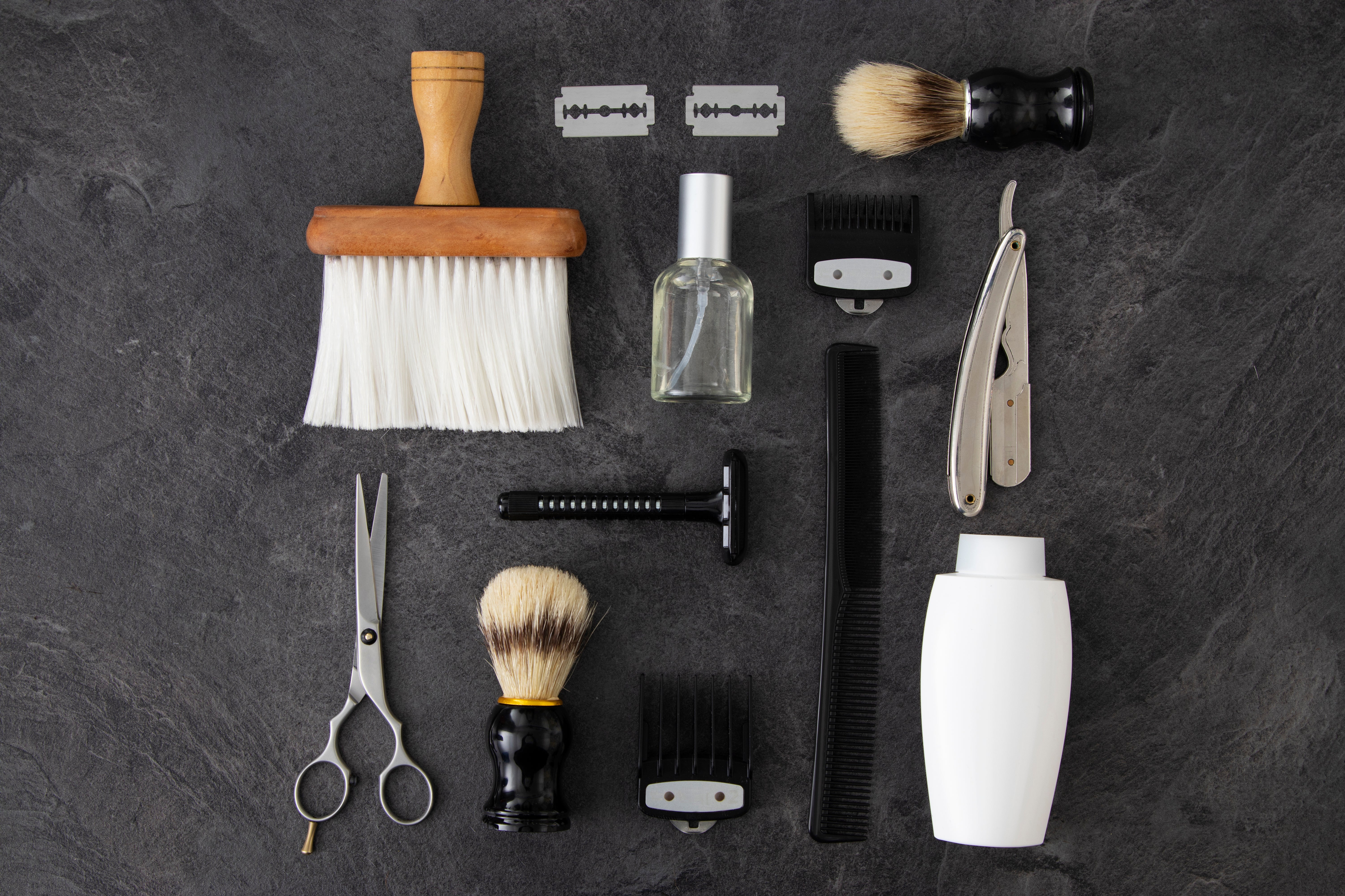 Photo de plusieurs accessoire de barbier ( ciseau, peigne, brosse, rasoir)
