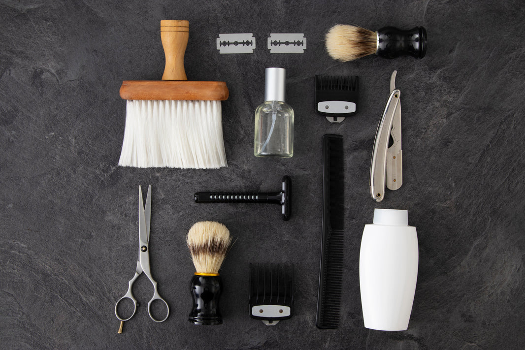Photo de plusieurs accessoire de barbier ( ciseau, peigne, brosse, rasoir)