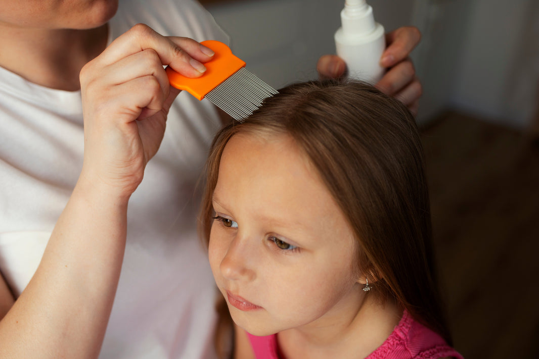 Photo d'une maman traitant les poux de sa fille avec un peigne anti-poux orange